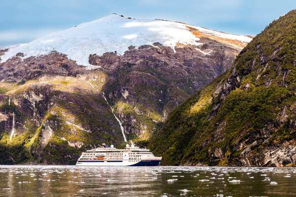Majestätische Fahrt durch die chilenischen Fjorde: Die HANSEATIC inspiration gleitet vorbei an schneebedeckten Bergen und malerischen Wasserfällen. Ein unvergleichliches Naturerlebnis erwartet die Gäste. © Hapag-Lloyd Cruises